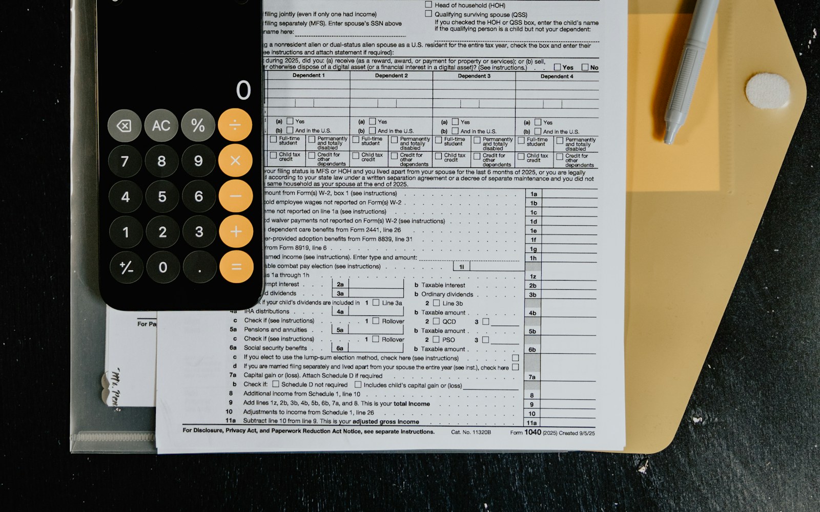 Tax forms with calculator and pen on desk
